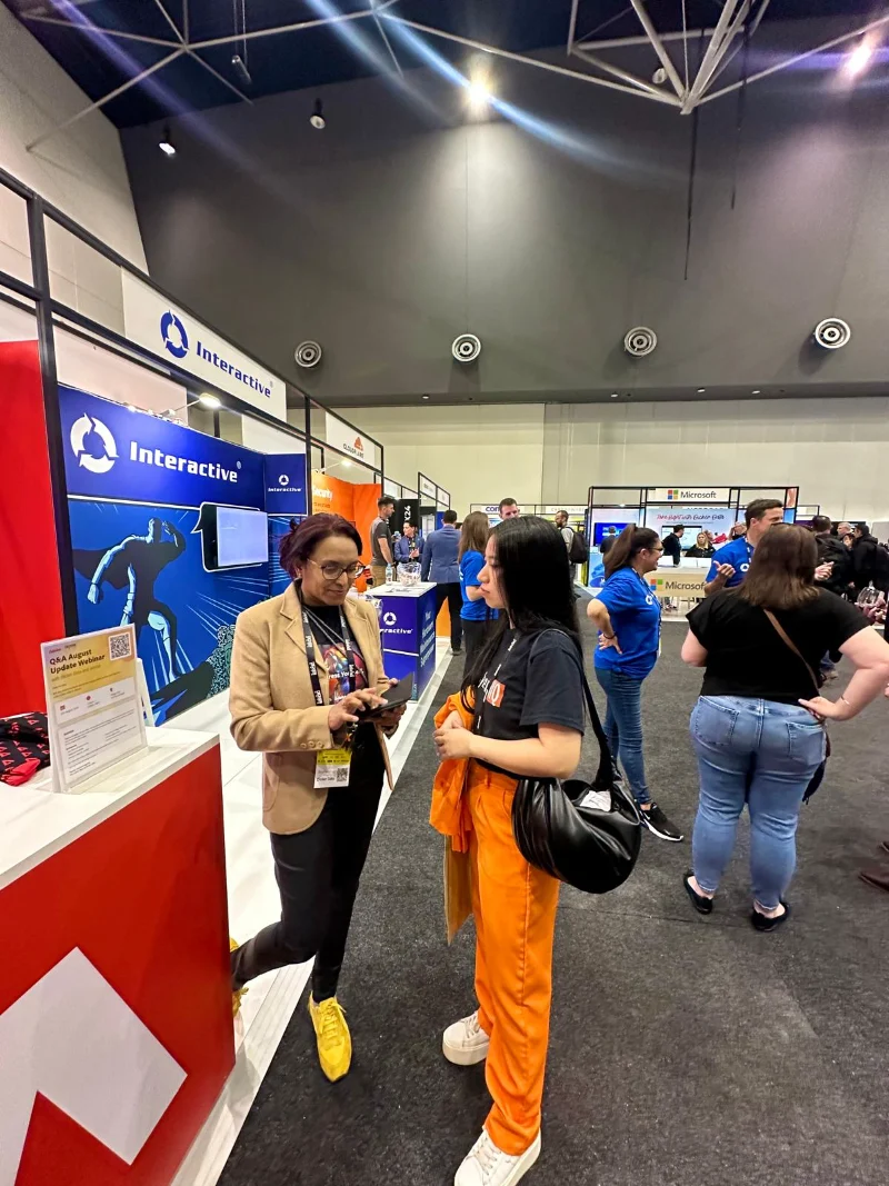Hoang from CyberNIQ talking with an exhibitor on the TechX floor